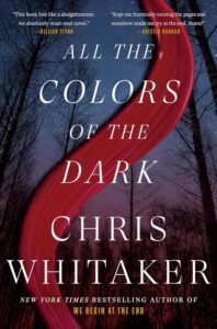 All the Colors of the Dark by Chris Whitaker book cover featuring a dark forest with a stripe of red across it 