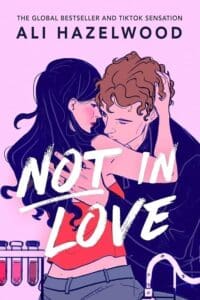 Not in Love by Ali Hazelwood book cover features pink background and couple in an embrace. 